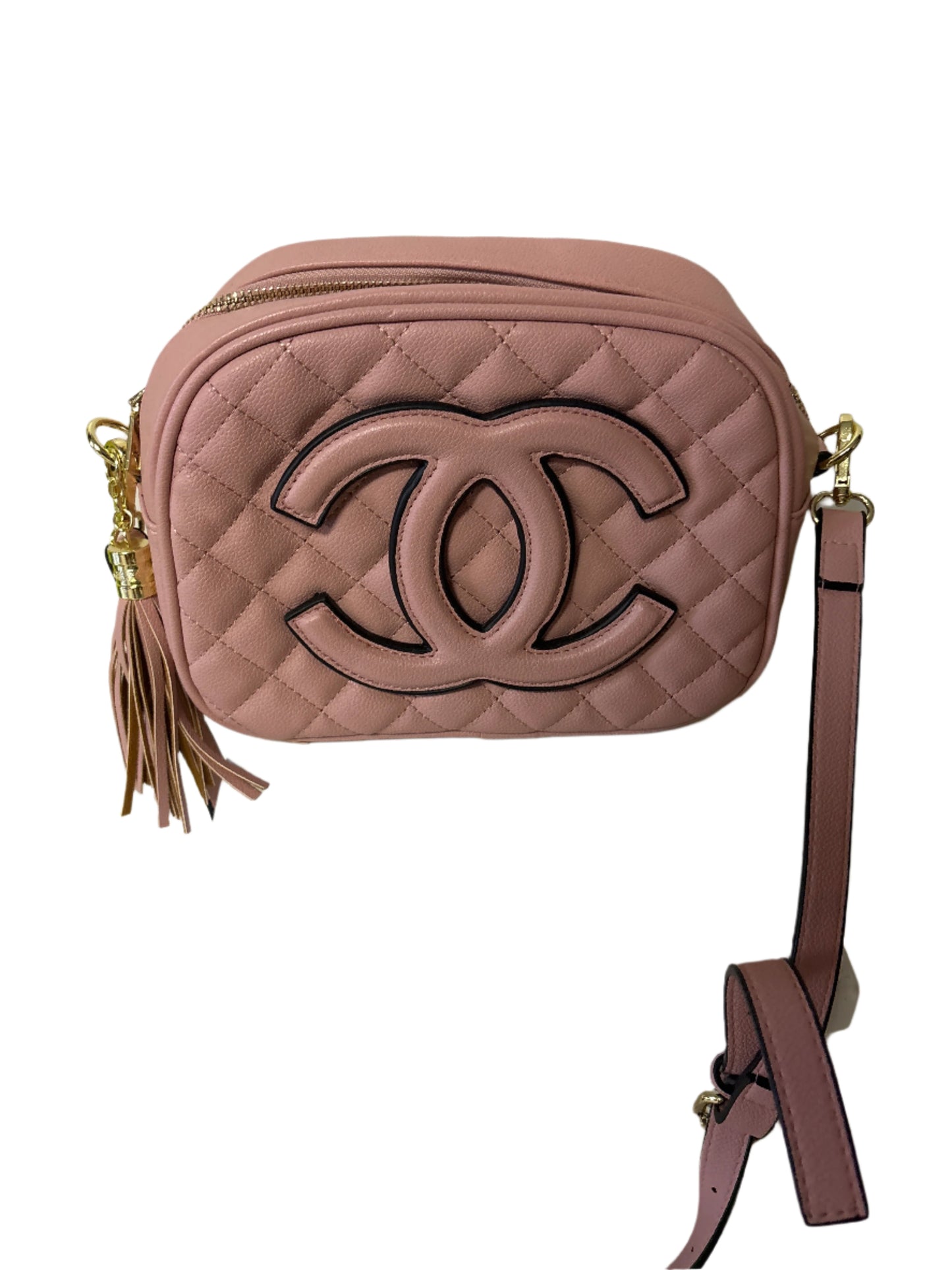Pink quilted handbag with a brand logo on a white stand against a light background