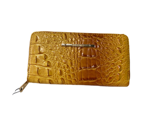 Yellow crocodile-patterned wallet on a white surface with a light gray background
