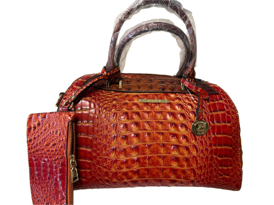 Brown crocodile-patterned handbag on a white surface with a green background